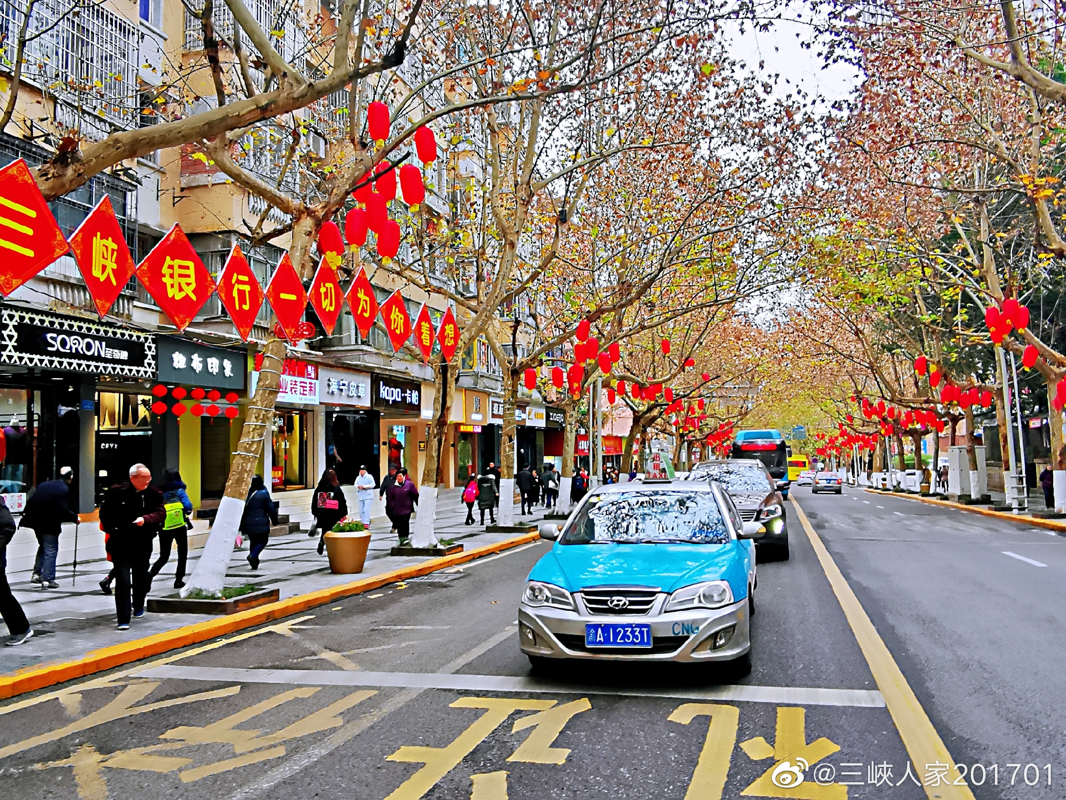 万州区白岩路树上挂着一串串红灯笼,红红的一条街,人行道上白色的,金